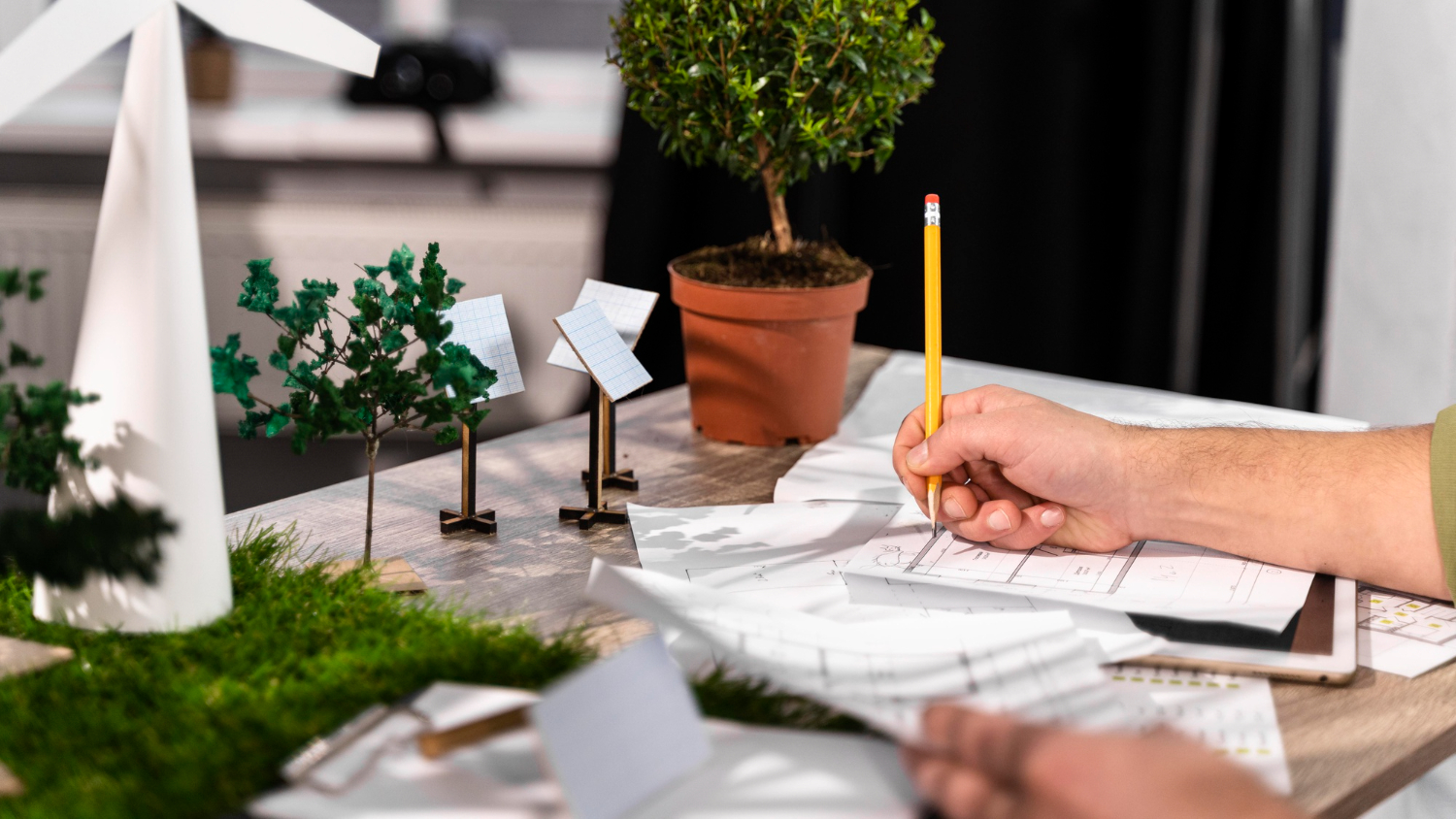 side-view-man-working-eco-friendly-wind-power-project-with-paper-plans (1)